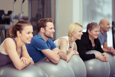 Frauen und Männer trainieren mit Gymnastikbällen