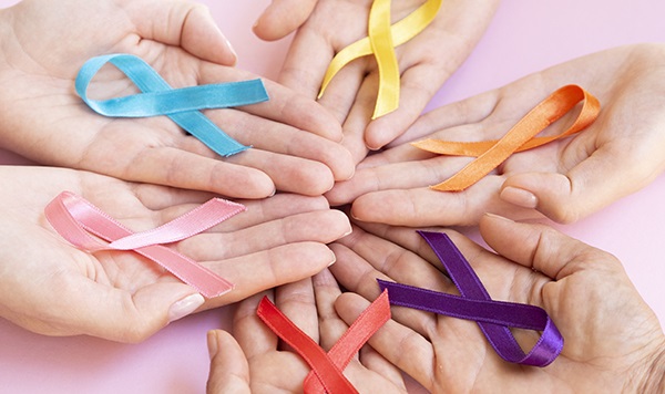 Sechs Hände mit bunten Awareness Ribbons